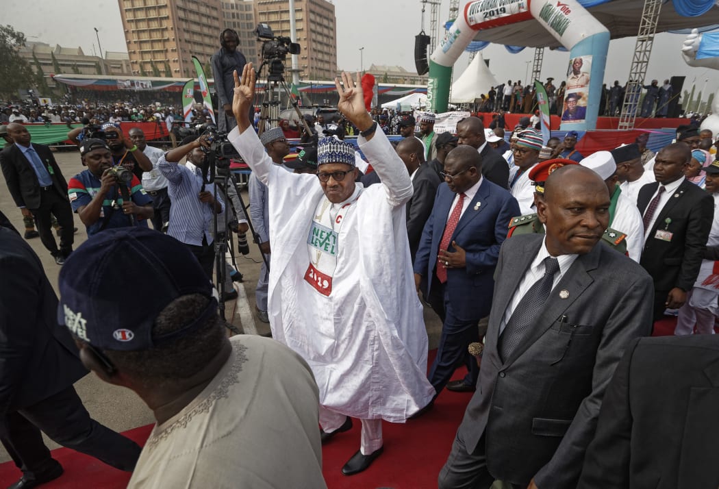 FILE - In this Wednesday, Feb. 13, 2019 file photo, incumbent President Muhammadu Buhari gestures to supporters at a campaign rally in Abuja, Nigeria.