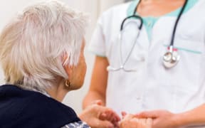 Young doctor giving helping hands for elderly woman