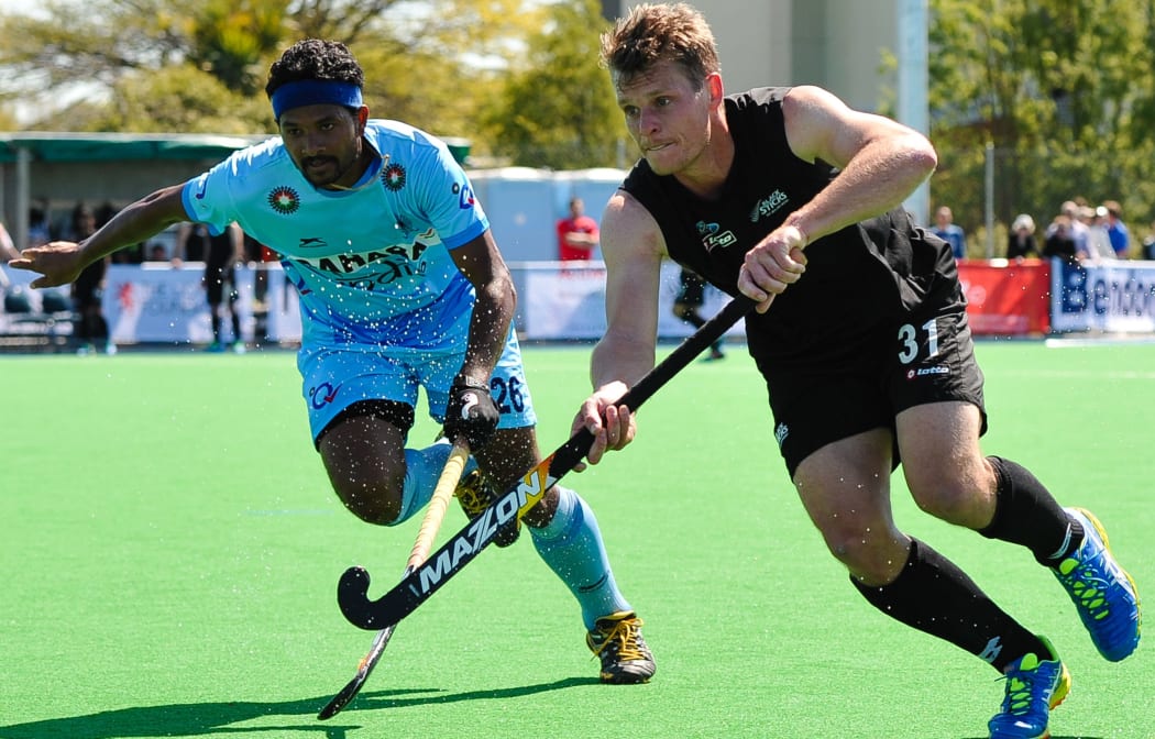Steve Edwards of the Black Sticks is tackled by Birendra Lakra of India.
