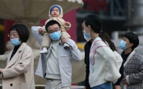 A baby is carried on the shoulders of a man in Beijing in March 2021.