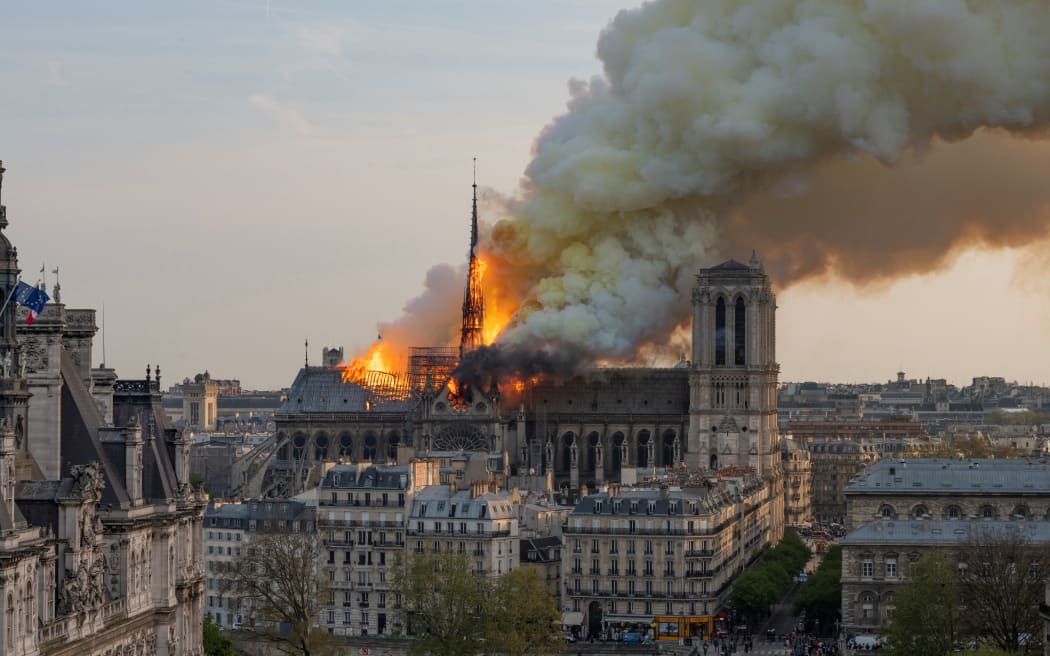 (FILES) Smoke billows as flames burn through the roof of the Notre-Dame de Paris Cathedral on April 15, 2019, in the French capital Paris. A huge fire swept through the roof of the famed Notre-Dame Cathedral in central Paris on April 15, 2019, and five years later, the reconstruction advances in its final stages before the reopening planned for the end of the year. (Photo by Fabien Barrau / AFP)