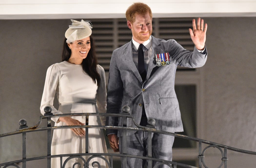 Britain's Prince Harry and and his wife Meghan, the Duchess of Sussex wave from the balcony of the Grand Pacific Hotel in Suva, Fiji.