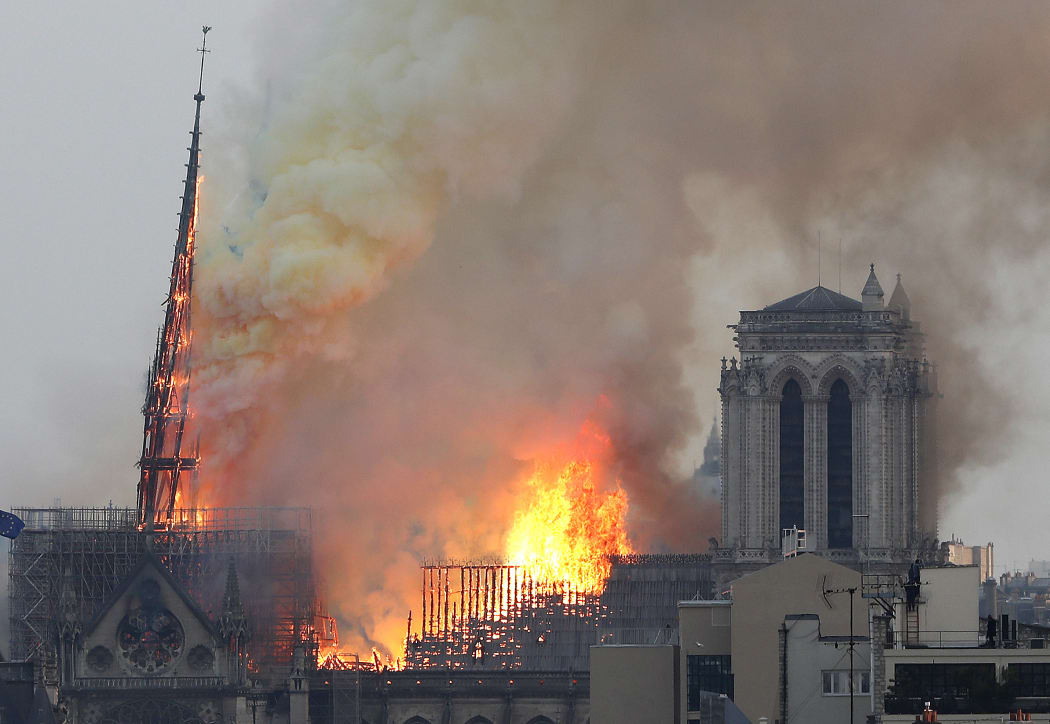 Flames engulf a spire of the medieval Notre-Dame Cathedral.