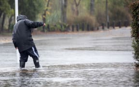 A man walks through the flood waters in Christchurch, NewÂ Zealand on May 30, 2021.Â MetService has put in place code red severe weather warning for the Canterbury region. (Photo by Sanka Vidanagama/NurPhoto via Getty Images)