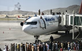 People climb on top of a plane at Kabul's airport on 16 August 2021, as thousands tried to flee the Taliban.