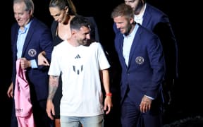 Lionel Messi (centre) and David Beckham talk during Inter Miami's "The Unveil" event at DRV PNK Stadium in Fort Lauderdale.