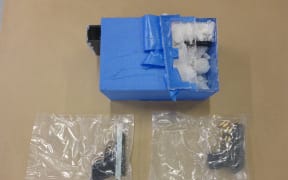 Closeup of methamphetamine and handguns.