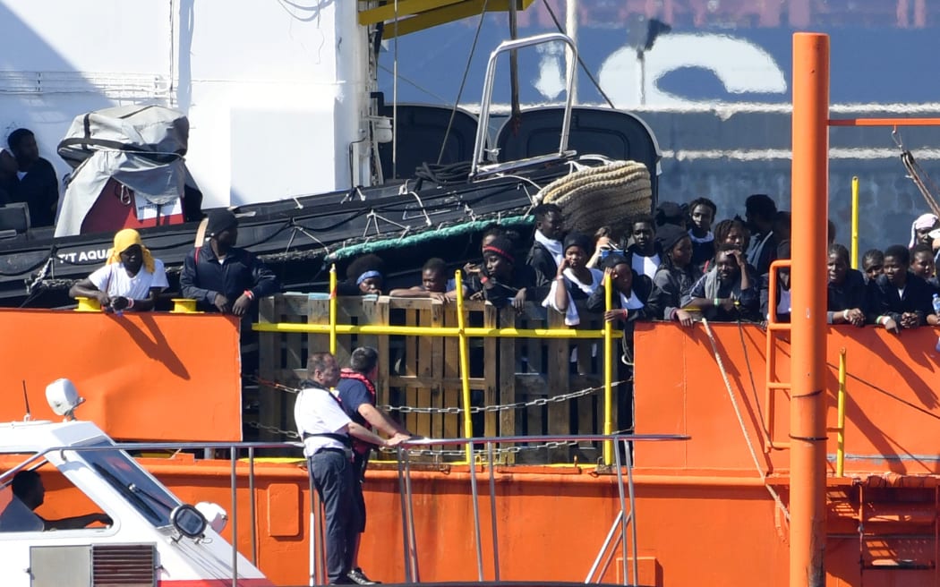 Migrants stand on the deck of the Aquarius as the ship enters the port of Valencia. The 630 migrants whose rescue sparked a major migration row in Europe began disembarking in Spain.