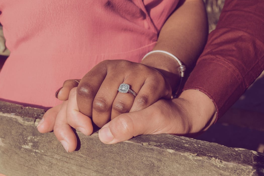 Closeup on hands of interracial engaged couple