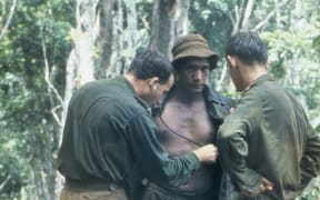 An Australian medical officer treating the New Zealand W Company during a resupply in the field during the Vietnam War.