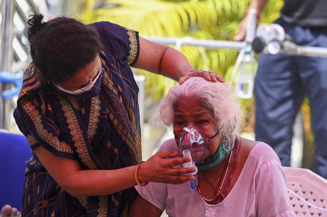 A Covid-19 patient breathes with the help of oxygen provided by a Gurdwara, a place of worship for Sikhs, under a tent installed along a roadside in Ghaziabad on 28 April 2021.
