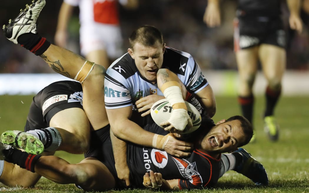 Bodene Thompson of the Warriors is tackled by Paul Gallen.