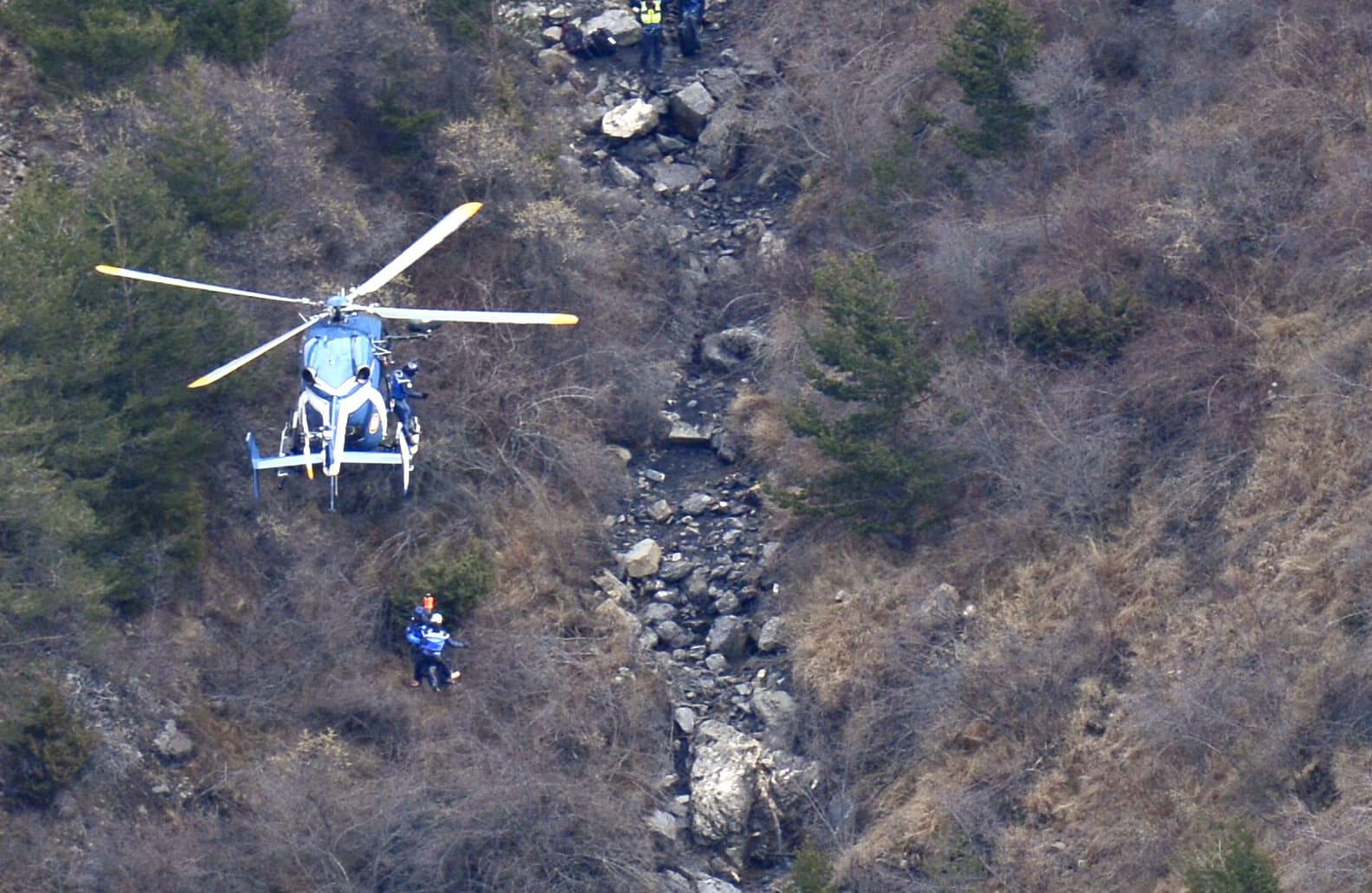 A helicopter lowers search and rescue personnel close to the crash site of the Germanwings Airbus A320 in the French Alps.
