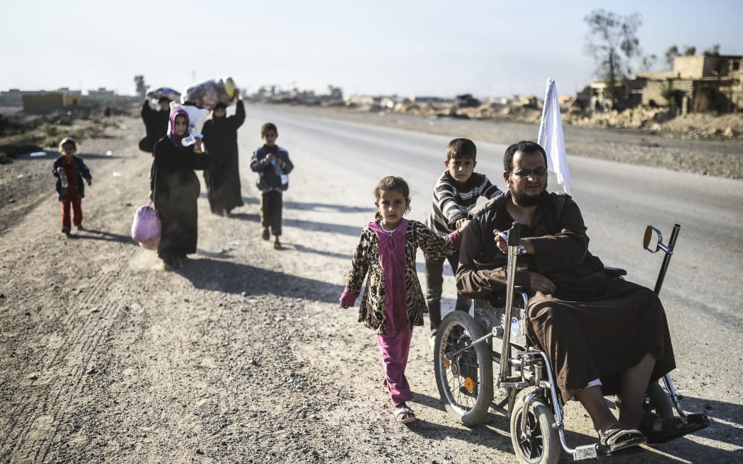 Iraqi families, who fled violence in and around Mosul arrive to board a truck before heading to camps housing displaced people near the village of Gogjali.