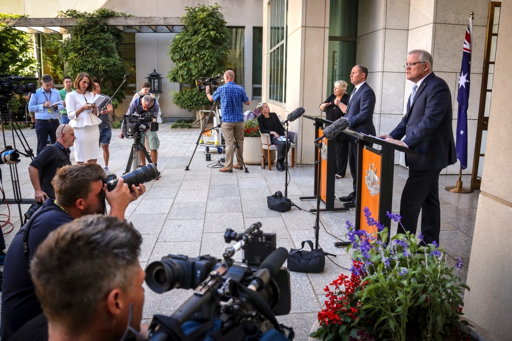 Australian Prime Minister Scott Morrison (R) speaks as he stands with the Australian Treasurer Josh Frydenberg during a press conference at Australia's Parliament House in Canberra on March 22, 2020