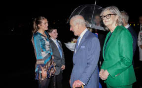 Britain's King Charles III speaks to 12-year-old Ky (2nd L) and his sister Charlotte (L) after they presented a bouquet of flowers to Queen Camilla at Sydney International Airport in Sydney on October 18, 2024, for a six-day royal visit to Sydney and Canberra. (Photo by Brook Mitchell / POOL / AFP)