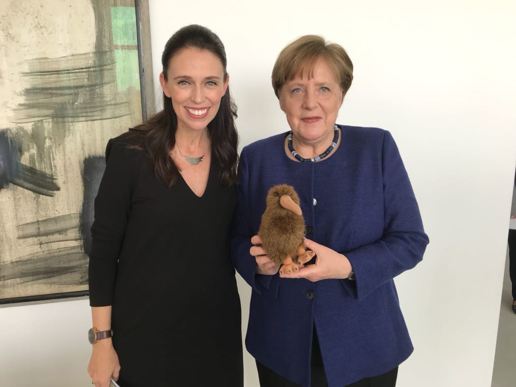 Jacinda Ardern and Angela Merkel with a kiwi soft toy.