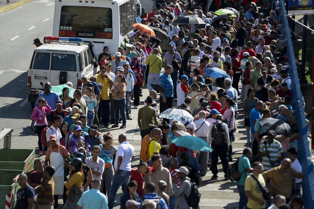 People queue outside Venezuela's Central Bank (BCV) in Caracas in an attempt to change 100-bolivar notes before they become worthless.