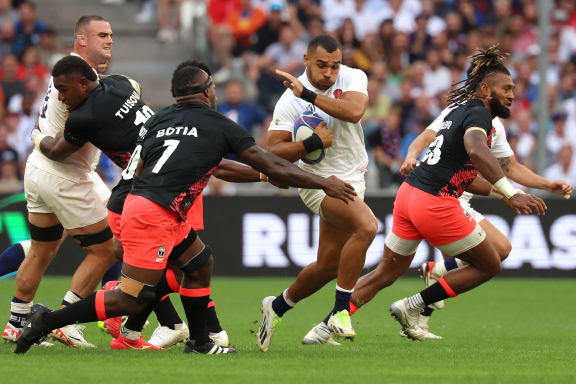 England's outside centre Joe Marchant (C) tries to avoid the tackle of Fiji's openside flanker Levani Botia (3rdL) during the France 2023 Rugby World Cup quarter-final match between England and Fiji at the Velodrome stadium in Marseille, south-eastern France, on October 15, 2023.