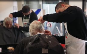 A trainee barber at Mr Barber cutting hair.