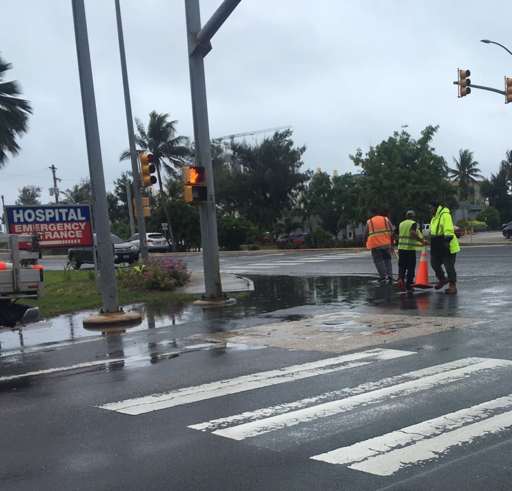 Saipan Mayor's Office staff put cones on major roads inundated by flash flooding.