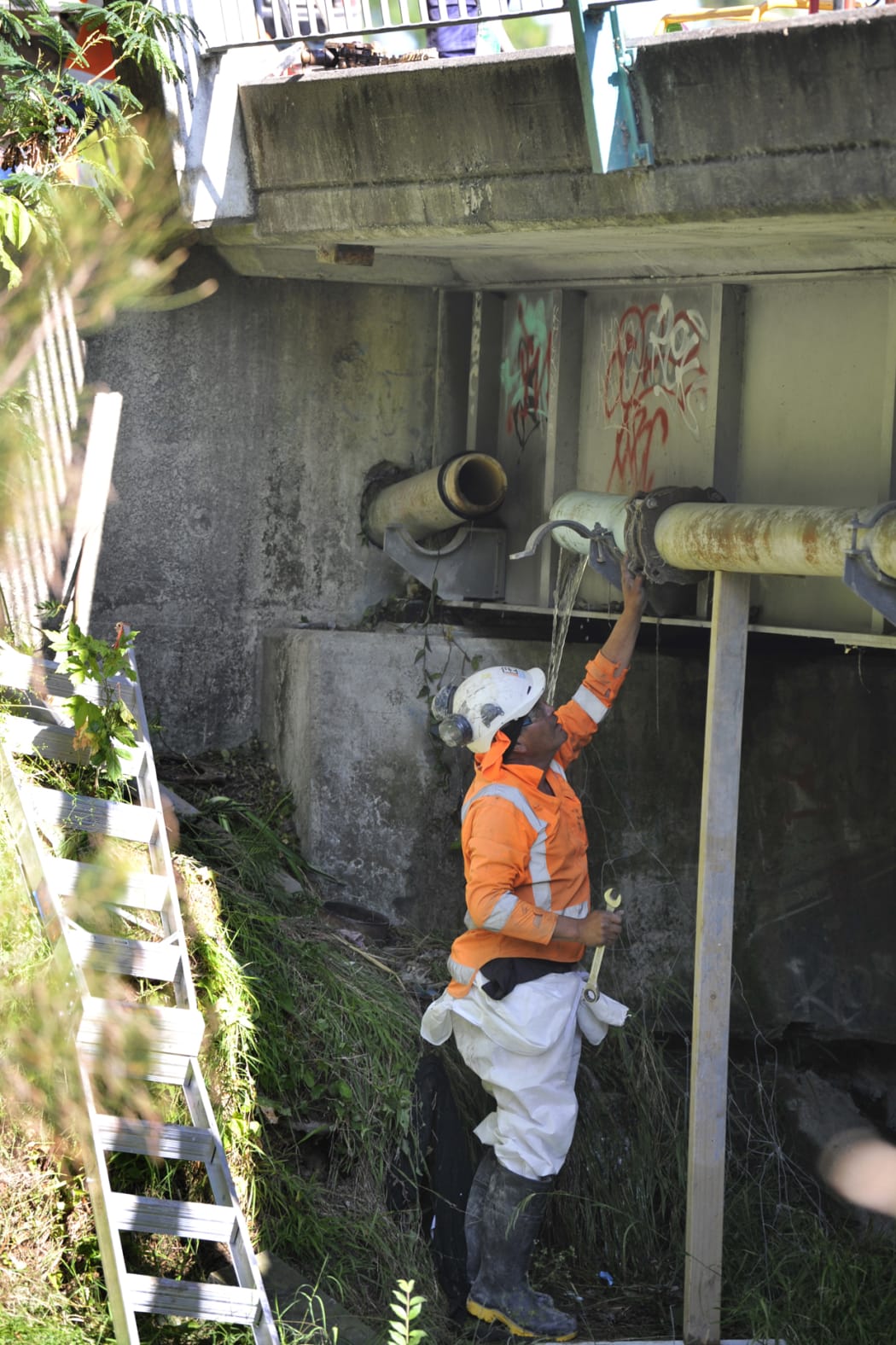 Fulton Hogan service person Tamati Teohera works to repair a broken water main on Nelson Road that has left 51 properties without water.