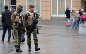Soldiers patrol streets in Brussels as the alert status is raised to the highest level.