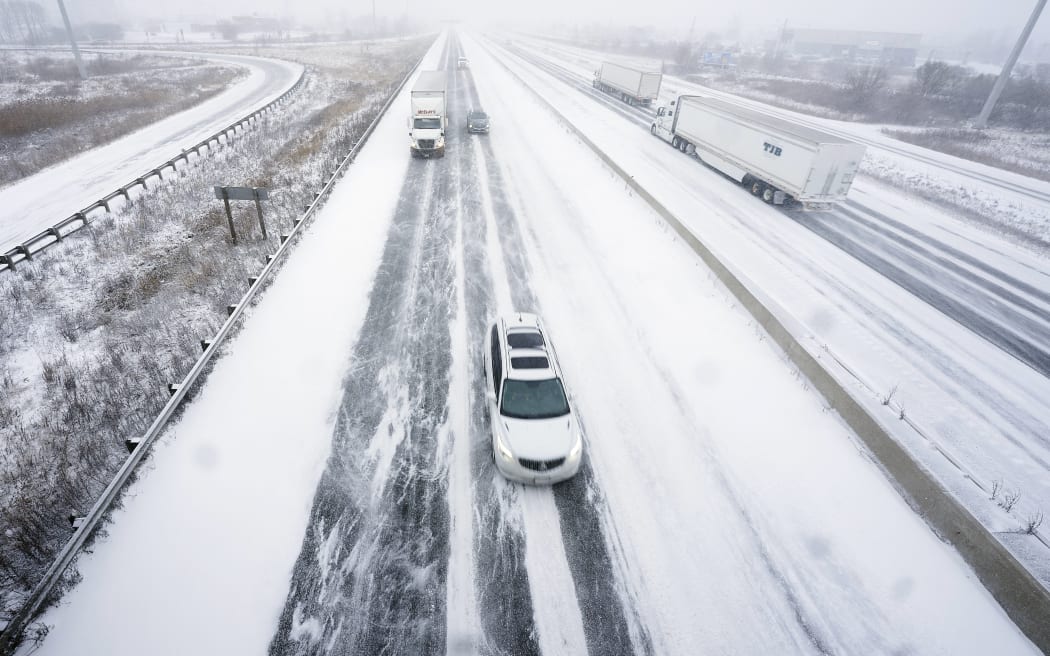 Traffic moves slowly along a snow-covered Highway 401 in London, Ontario, Canada, during a large winter storm on December 23, 2022. - Schools and some highways in the region were closed, and air travel was disrupted as the system made its way across the province. (Photo by Geoff Robins / AFP)