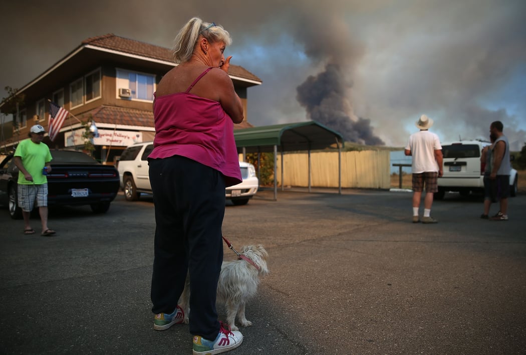 Residents watch a large plume of smoke from the Rocky Fire in California.