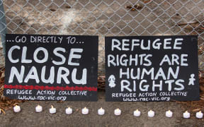 Two banners and candles at the gates of a refugee detention centre during a candlelight vigil. Asanka Brendon Ratnayake / Anadolu Agency