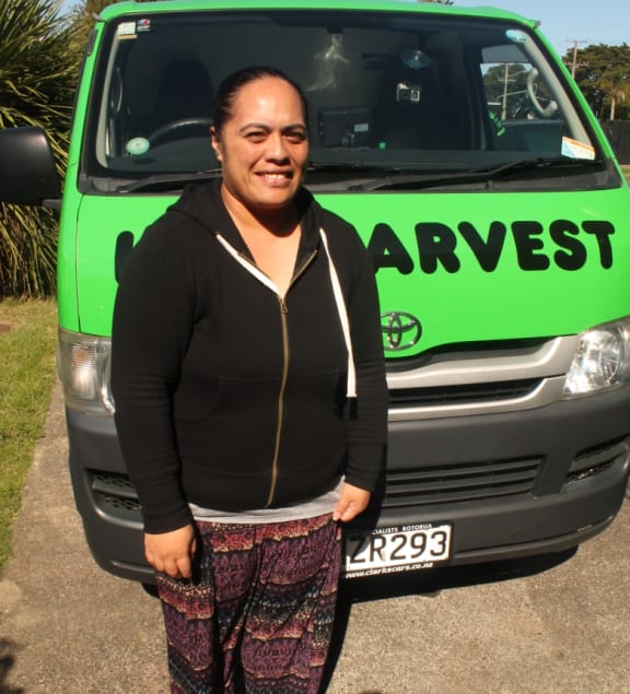 An image of Karaona Paul, an administrator at Te Roopu o Te Whanau Rangimarie o Tamaki Makaurau in Otahuhu, standign in front of the Kiwi Harvest van.