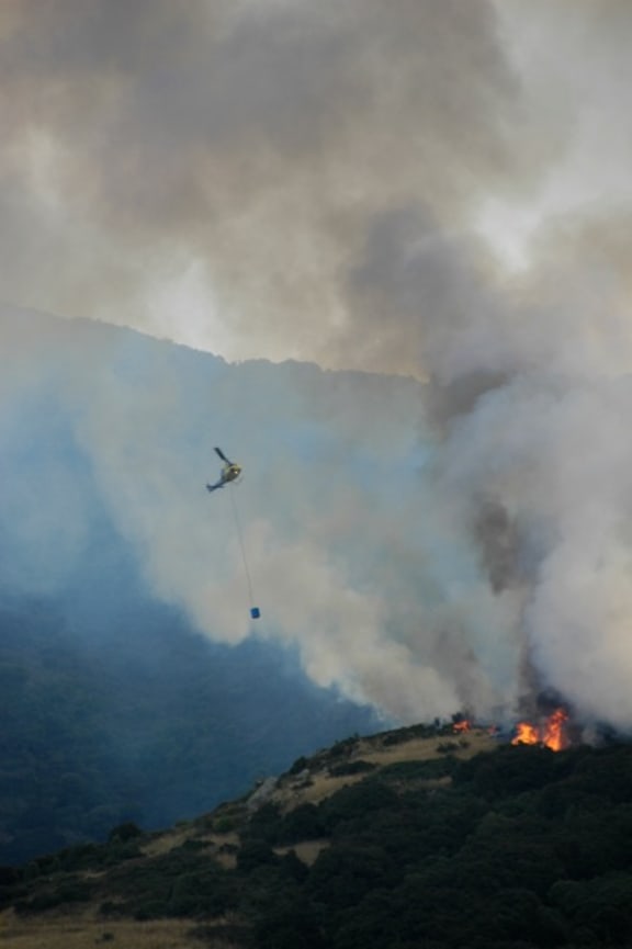 A helicopter fights the fire near Governors Bay in Christchurch's Port Hills.