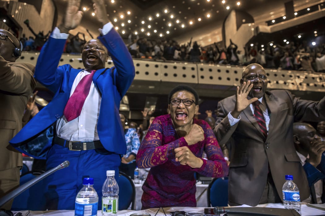 Members of Zimbabwe's parliament celebrate after Mr Mugabe's resignation.