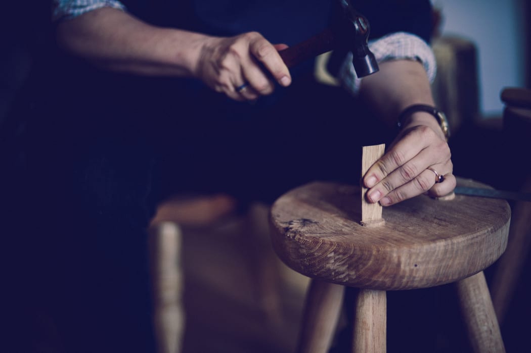 Juliet Arnott knocking in an oak wedge into a greewnwood stool made from ash elm from Hagley Park. Image by Justyn Rebecca Denney