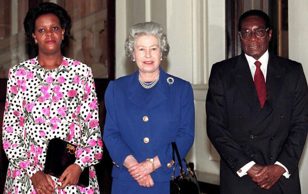This file photo taken on February 03, 1997 shows Britain's Queen Elizabeth II with President Robert Mugabe of Zimbabwe and his wife Grace, posing for photographers after being the Queen's guest at Buckingham Palace.