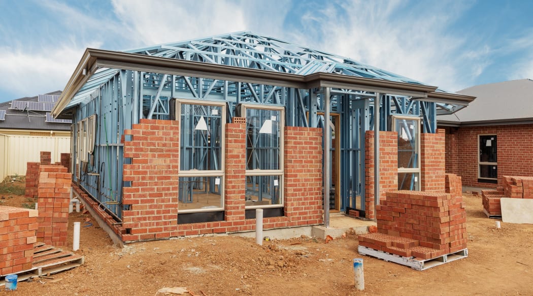 New residential construction home from brick with metal framing against a blue sky