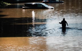 NEW YORK CITY - SEPTEMBER 02: A man walks through a flooded Major Deegan Expressway in the Bronx as dozens of cars and trucks sit abandoned following as night of heavy wind and rain from the remnants of Hurricane Ida on September 02, 2021 in New York City.