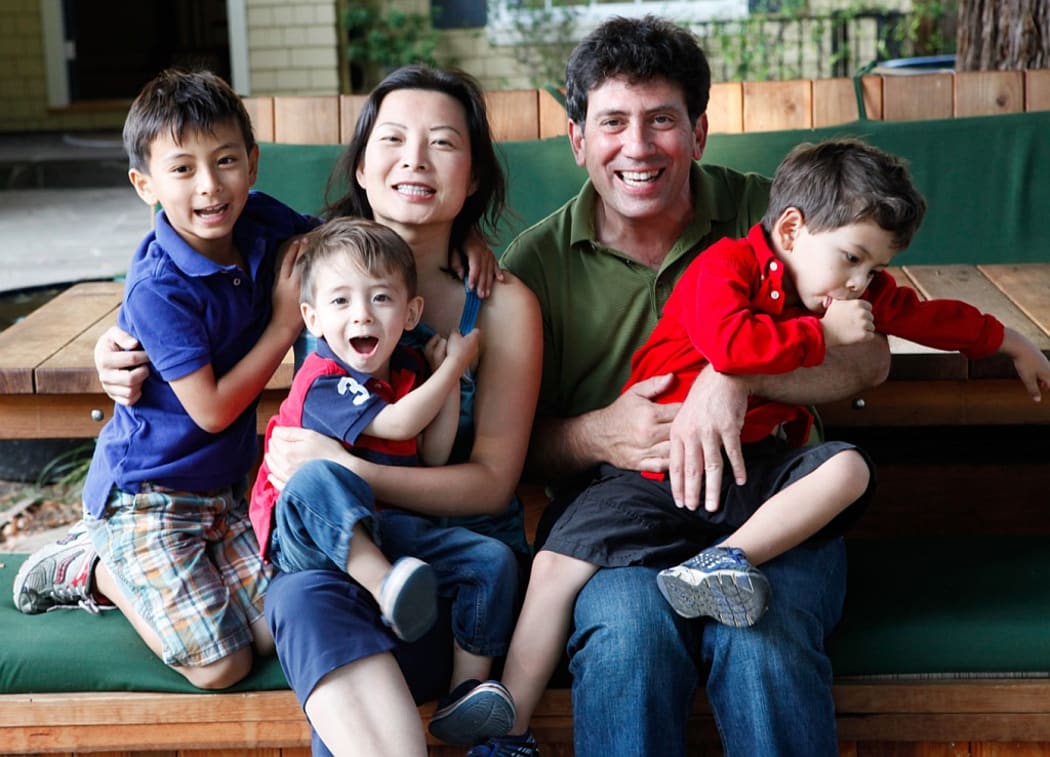 Mike Lanza at his front yard picnic table, surrounded by his family: from left, Marco (7), Leo (2), wife Perla Ni, and Nico (4).