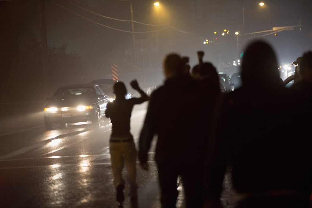 Demonstrators march in the rain on 9 August in Ferguson.