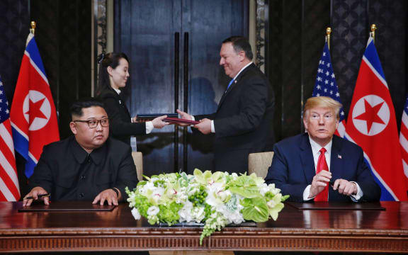 US President Donald Trump and North Korea's leader Kim Jong Un participate in a signing ceremony as part of the US-North Korea summit, at the Capella Hotel on Sentosa Island in Singapore on June 12, 2018.