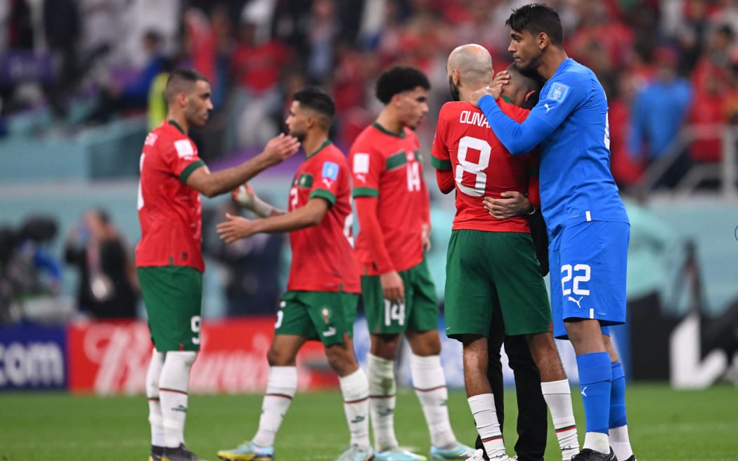 Morocco's goalkeeper Ahmed Reda Tagnaouti (22), comforts Morocco's midfielder Azzedine Ounahi (8) after the Qatar 2022 World Cup semi-final loss against France. at the Al-Bayt Stadium in Al Khor, north of Doha on December 14, 2022.