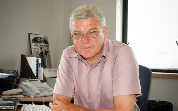 Photo of Peter Lineham sitting at his desk, leaning forward.