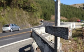 A cross stands on State Highway 5, marking the spot of a fatal crash on the road