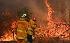 Firefighters tackle a bushfire to save a home in Taree, 350km north of Sydney, on 9 November.