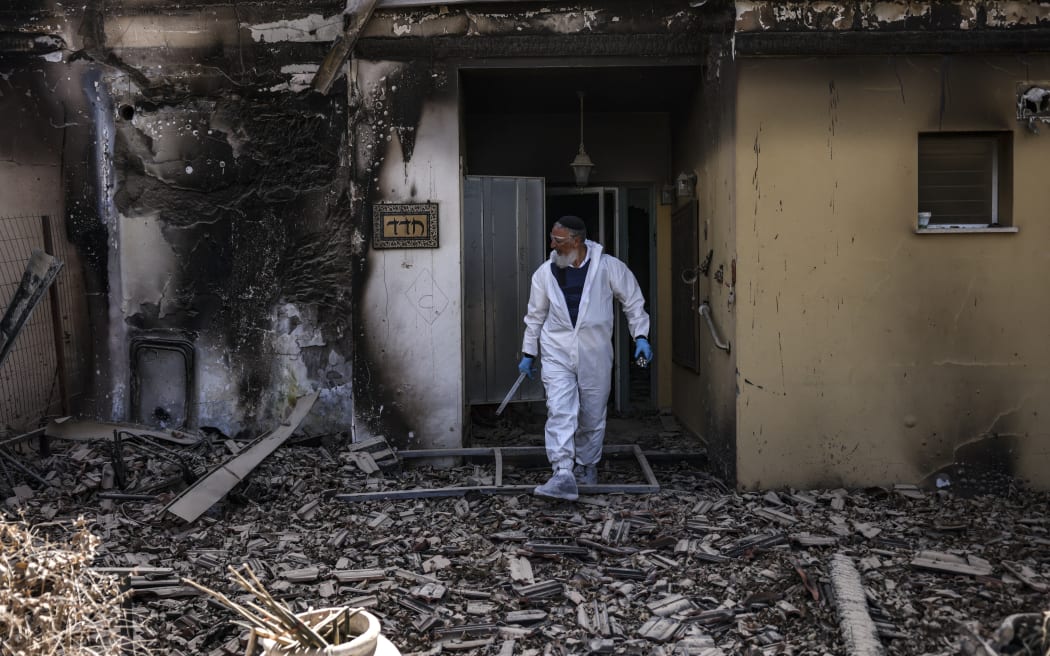 A volunteer of the Zaka Israeli ultra-Orthodox Jewish emergency response team searches through the debris in Kibbutz Beeri near the border with Gaza on October 20, 2023, in the aftermath of an attack by Palestinian militants on October 7. (Photo by RONALDO SCHEMIDT / AFP)
