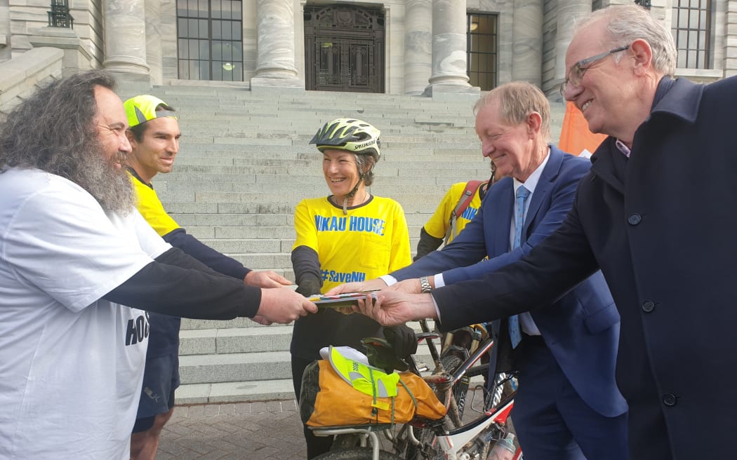 Katrina Marwick (centre) and Nikau House member Daniel Timms (far left) deliver a petition against the proposed closure of the mental health facility to Nelson MP Nick Smith at the steps of Parliament on 17 July, 2020.