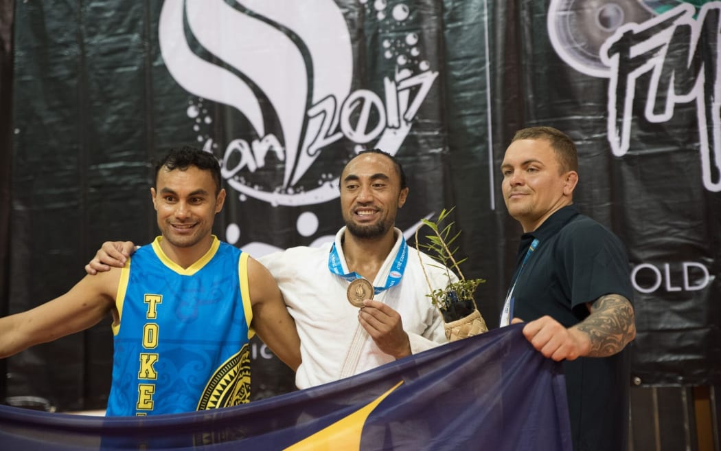 Peter Elekana, Ilau Elekana Manu (c) and team official Pavel Kondakov celebrate Tokelau's bronze medal at the Pacific Mini Games.