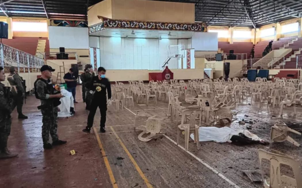 Security personnel survey the damage at Mindanao State University's gymnasium in the Philippines after an explosion ripped through the building.