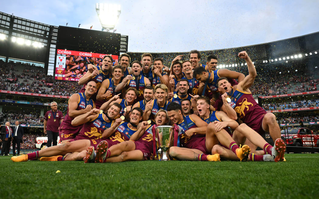 Brisbane Lions players celebrate winning the AFL Grand Final between the Sydney Swans and the Brisbane Lions at the Melbourne Cricket Ground, 2024.