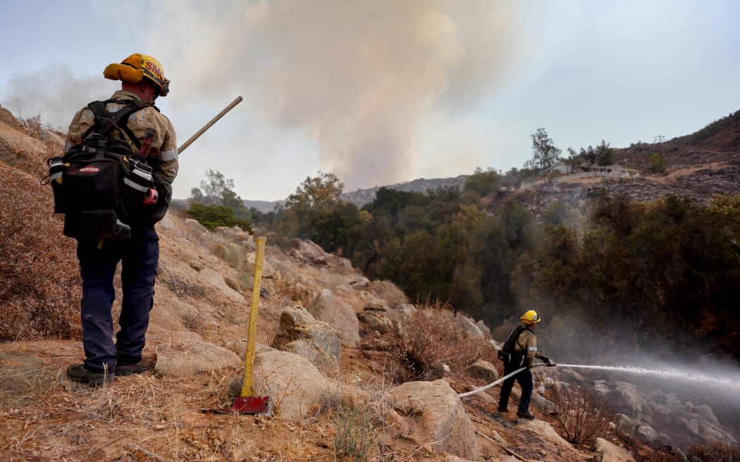 HEMET, CALIFORNIA - SEPTEMBER 06: Firefighters work as the Fairview Fire burns on September 6, 2022 near Hemet, California. The 2,400-acre brush fire left two dead and has destroyed several homes amid an intense heat wave in Southern California. The National Weather Service issued an Excessive Heat Warning for much of Southern California through September 8.   Mario Tama/Getty Images/AFP (Photo by MARIO TAMA / GETTY IMAGES NORTH AMERICA / Getty Images via AFP)